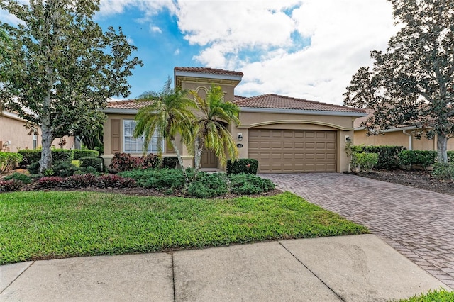 mediterranean / spanish-style home featuring a front yard and a garage