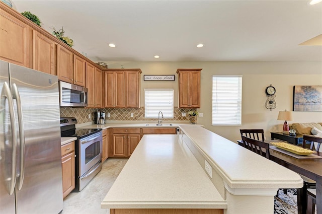 kitchen featuring tasteful backsplash, sink, a center island, and appliances with stainless steel finishes