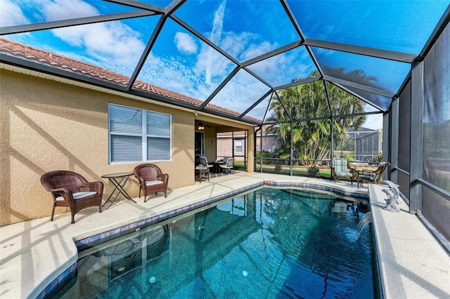 view of pool with pool water feature, a lanai, and a patio area