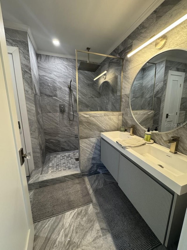 bathroom featuring tiled shower, vanity, tile walls, and ornamental molding