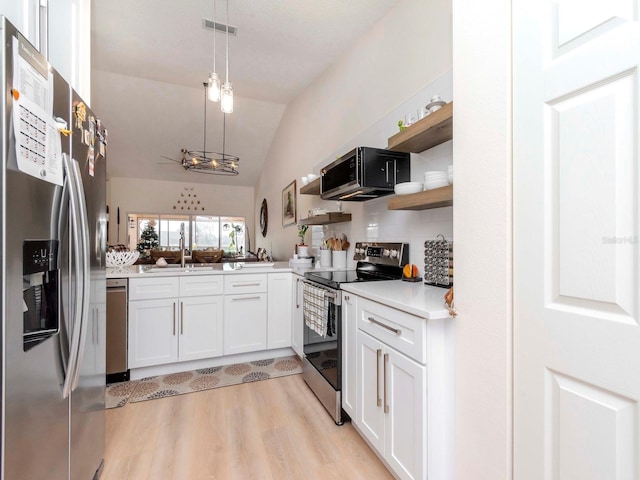 kitchen with stainless steel appliances, pendant lighting, vaulted ceiling, decorative backsplash, and white cabinets