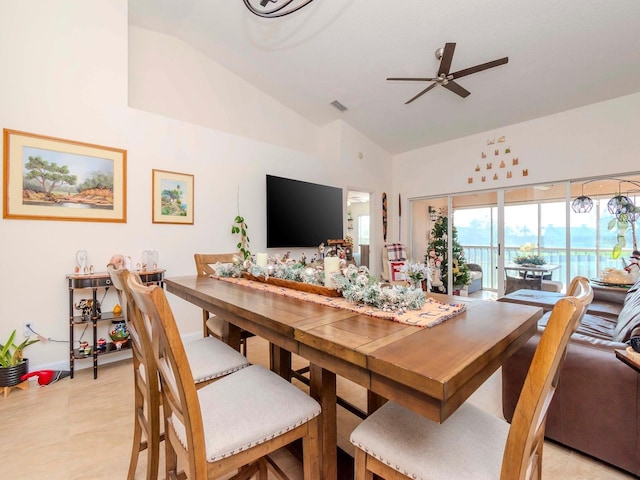 tiled dining area with ceiling fan and high vaulted ceiling