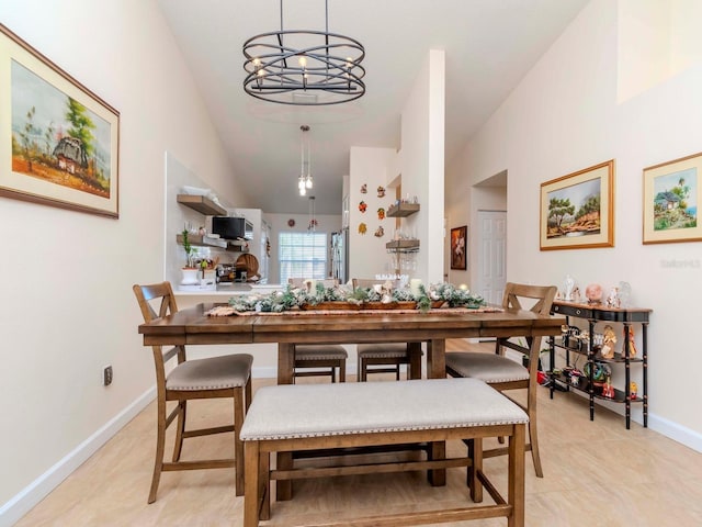 tiled dining space featuring high vaulted ceiling and a notable chandelier