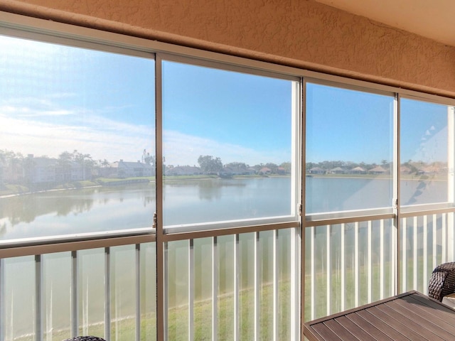 unfurnished sunroom featuring a water view and a wealth of natural light