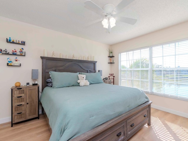 bedroom with multiple windows, light wood-type flooring, and ceiling fan