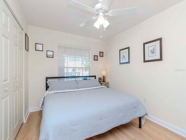 bedroom featuring ceiling fan, a closet, a textured ceiling, and light hardwood / wood-style flooring