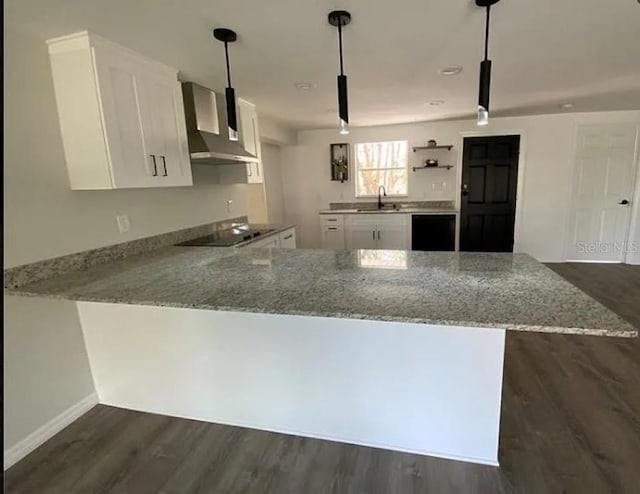 kitchen with kitchen peninsula, decorative light fixtures, white cabinetry, and light stone counters