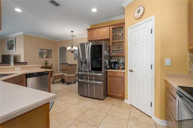 kitchen with light tile patterned floors, ornamental molding, decorative light fixtures, and appliances with stainless steel finishes