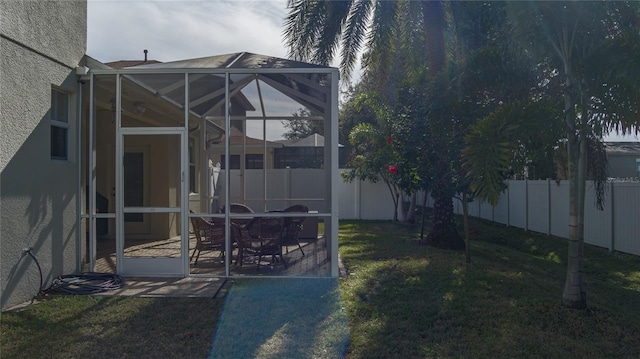 view of yard featuring glass enclosure and a patio