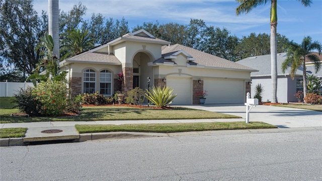 3439 101st Ave E, Parrish, FL 34219 - view of front of house featuring a garage, concrete driveway, stucco siding, and a shingled roof