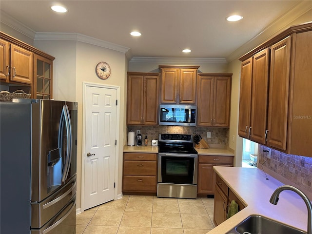 3439 101st Ave E, Parrish, FL 34219 - kitchen with stainless steel appliances, light countertops, brown cabinetry, crown molding, and backsplash