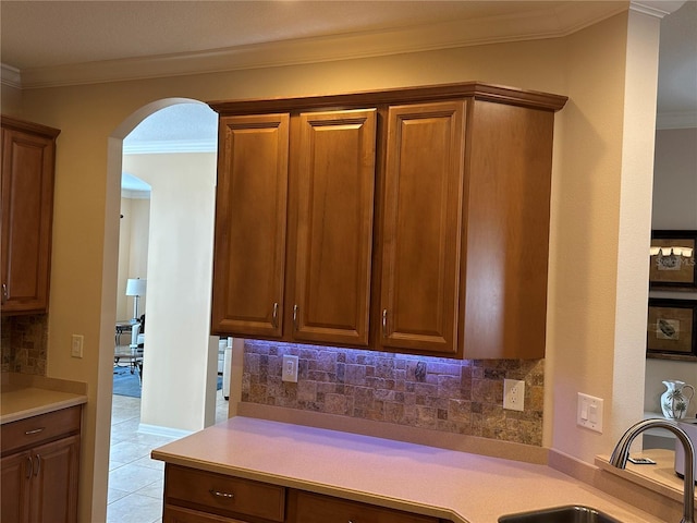 3439 101st Ave E, Parrish, FL 34219 - kitchen with arched walkways, ornamental molding, light countertops, decorative backsplash, and light tile patterned flooring