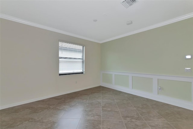 spare room featuring light tile patterned flooring and ornamental molding