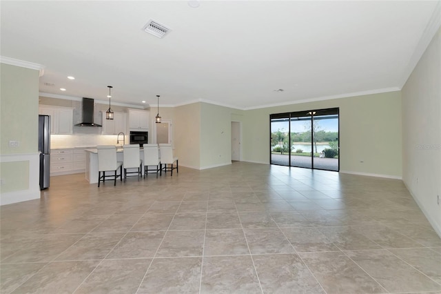 unfurnished living room featuring light tile patterned floors and crown molding