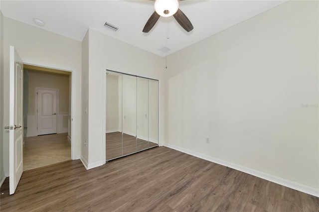 unfurnished bedroom featuring wood-type flooring, ceiling fan, and a closet