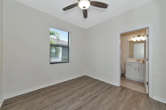 unfurnished bedroom with sink, ceiling fan, light hardwood / wood-style flooring, and connected bathroom