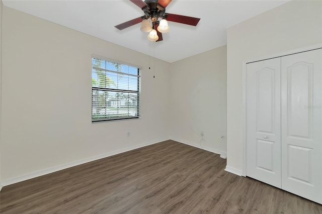 unfurnished bedroom with ceiling fan, a closet, and dark hardwood / wood-style floors