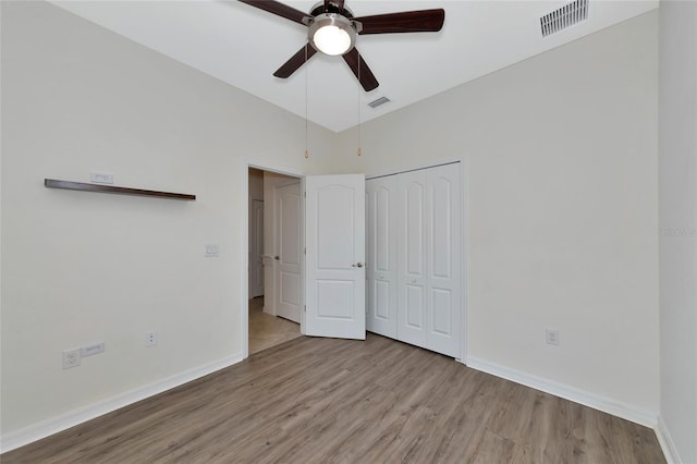 unfurnished bedroom featuring ceiling fan, light hardwood / wood-style floors, and a closet