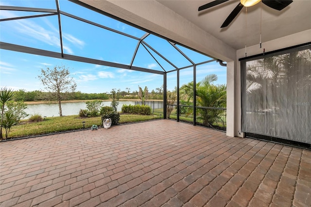 view of patio with a lanai, ceiling fan, and a water view