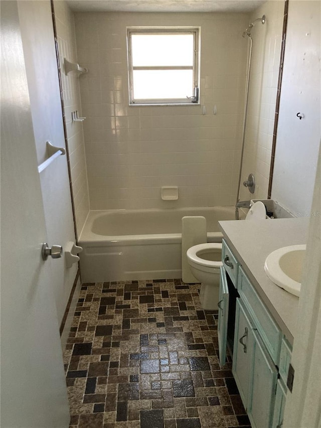 full bathroom featuring vanity, tiled shower / bath combo, and toilet