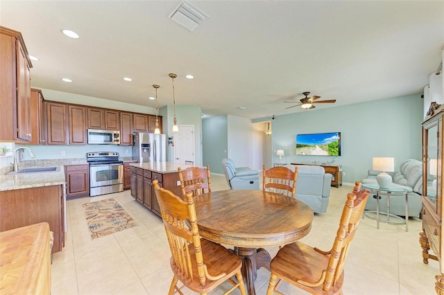 dining area with ceiling fan, light tile patterned flooring, and sink