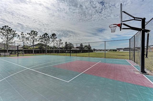 view of sport court with a lawn