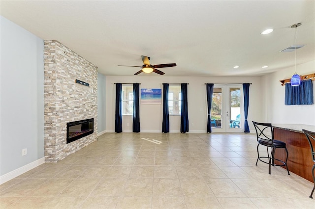 living room featuring ceiling fan, light tile patterned floors, a fireplace, and french doors