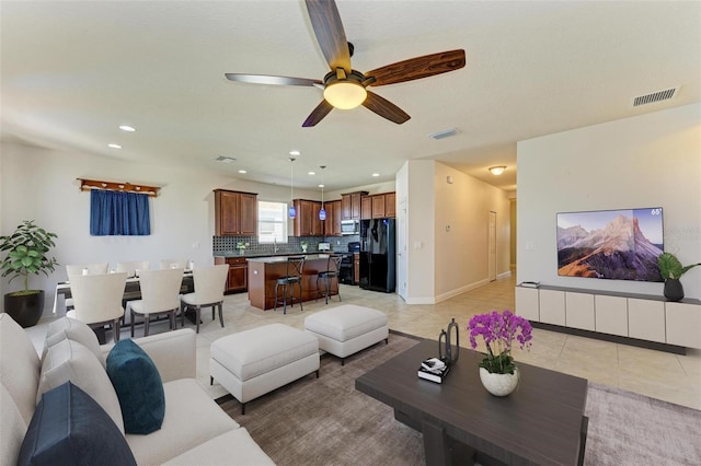 tiled living room with ceiling fan