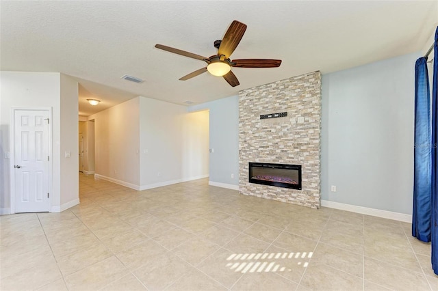 unfurnished living room with a fireplace, a textured ceiling, ceiling fan, and light tile patterned flooring