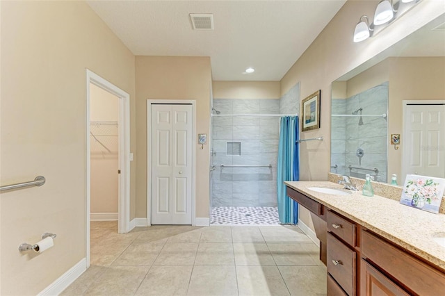 bathroom featuring tile patterned flooring, vanity, and walk in shower