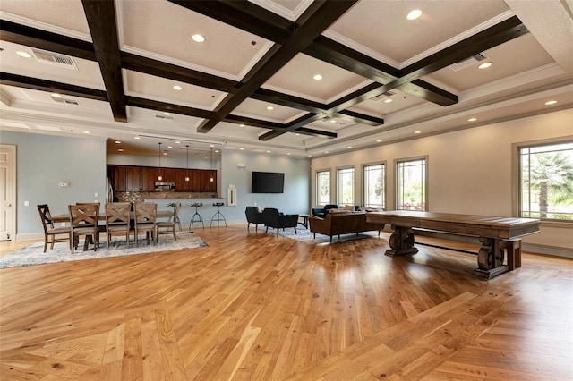 unfurnished living room featuring a healthy amount of sunlight, light hardwood / wood-style floors, ornamental molding, and coffered ceiling