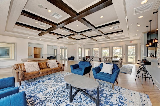 living room featuring beam ceiling, light wood-type flooring, ornamental molding, and coffered ceiling