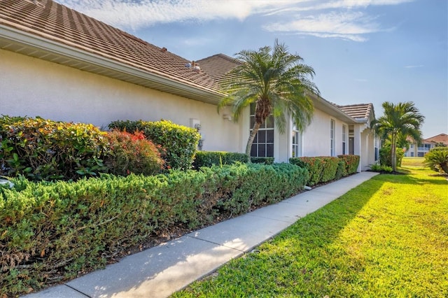 view of side of home with a yard