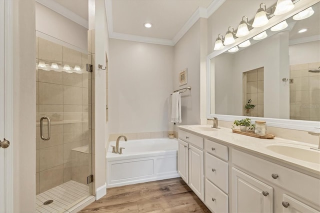 bathroom featuring plus walk in shower, wood-type flooring, vanity, and ornamental molding