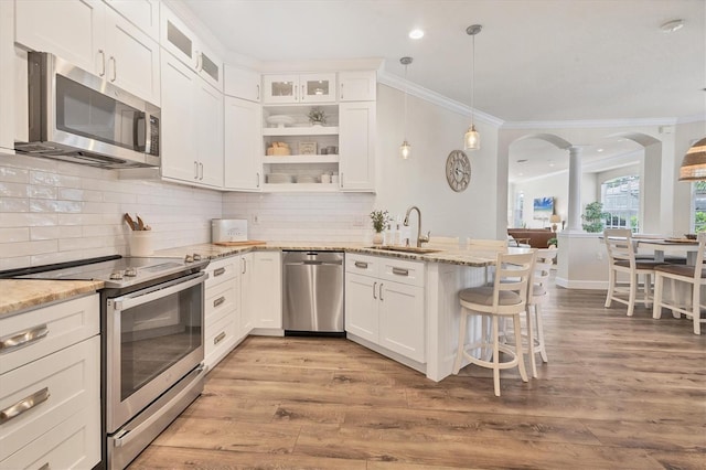 kitchen with light stone countertops, sink, white cabinets, and stainless steel appliances