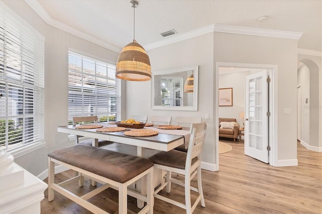 dining area with light hardwood / wood-style flooring and ornamental molding