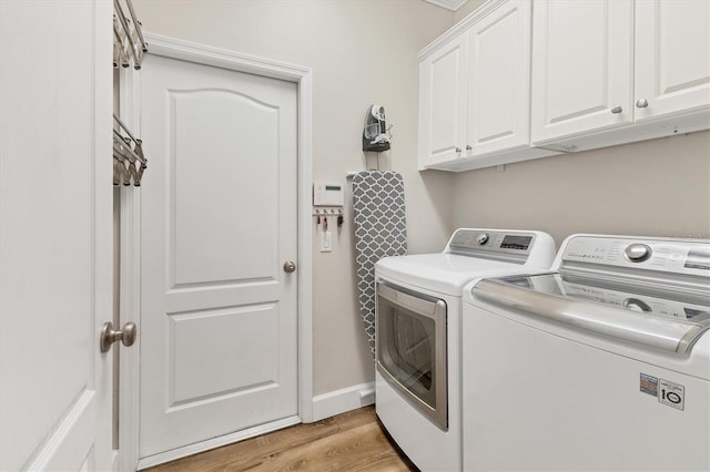 laundry room with cabinets, independent washer and dryer, and light wood-type flooring