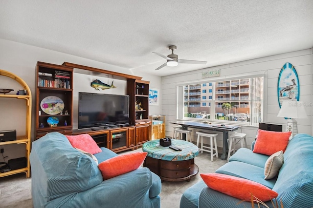 living room featuring ceiling fan and a textured ceiling