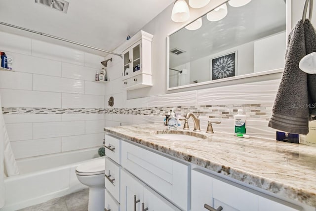 full bathroom featuring vanity, backsplash, tile patterned flooring, toilet, and shower / tub combo