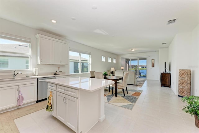 kitchen with white cabinetry, sink, a kitchen island, and stainless steel dishwasher