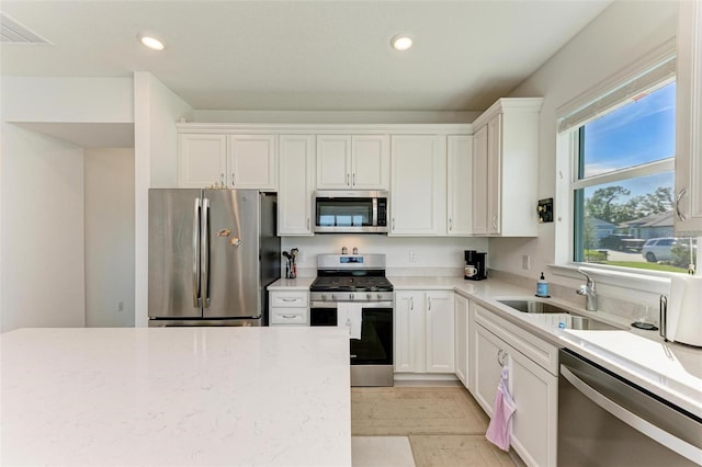 kitchen featuring white cabinetry, sink, and appliances with stainless steel finishes