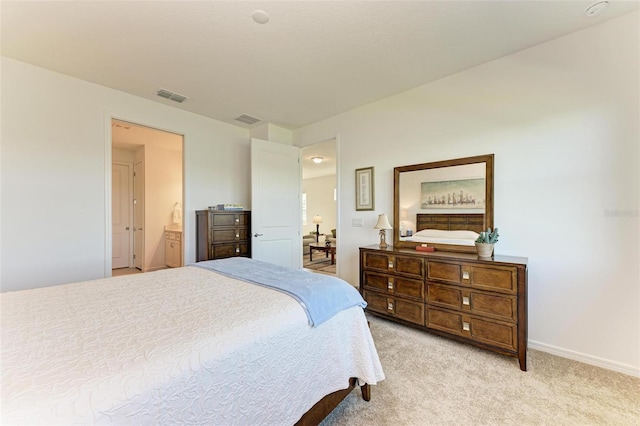 bedroom with light colored carpet and connected bathroom