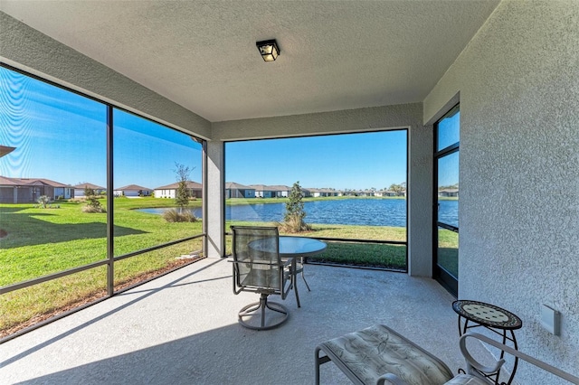 sunroom / solarium with a water view and a healthy amount of sunlight