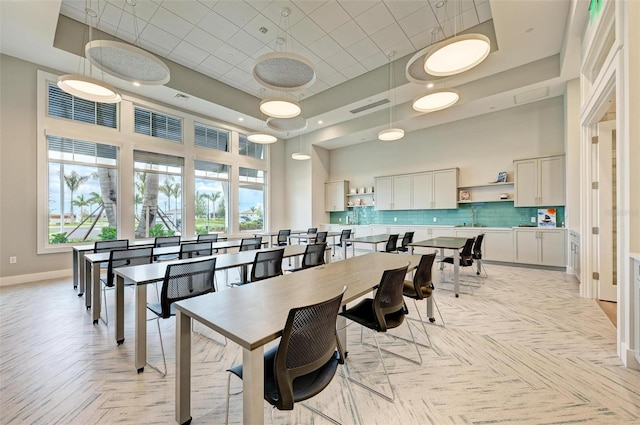 dining space featuring a high ceiling and light parquet flooring