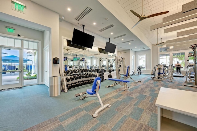 exercise room with carpet flooring and a high ceiling