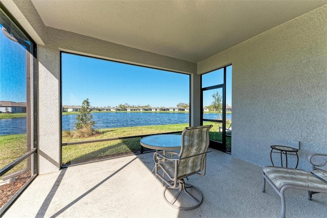 sunroom / solarium featuring a water view