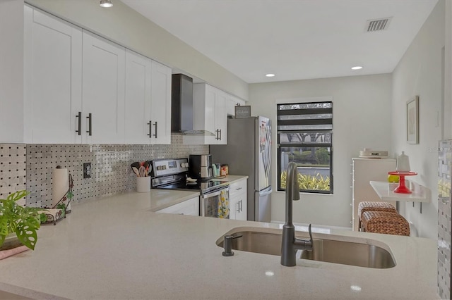 kitchen featuring backsplash, white cabinets, sink, wall chimney exhaust hood, and stainless steel appliances