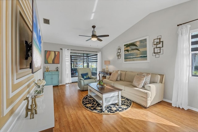 living room with ceiling fan, vaulted ceiling, and light wood-type flooring