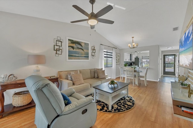 living room featuring ceiling fan with notable chandelier, light hardwood / wood-style flooring, and lofted ceiling