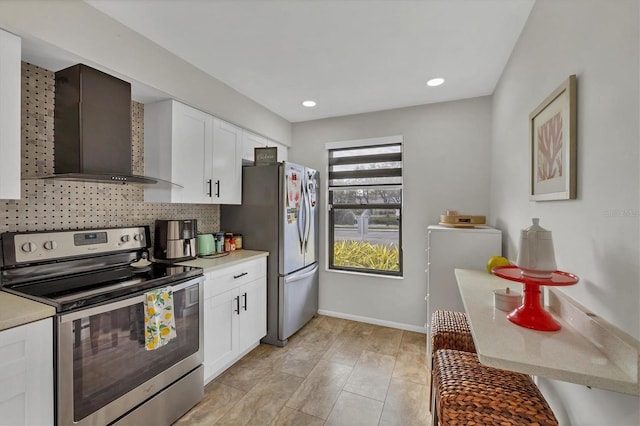 kitchen featuring backsplash, wall chimney range hood, appliances with stainless steel finishes, washer / dryer, and white cabinetry